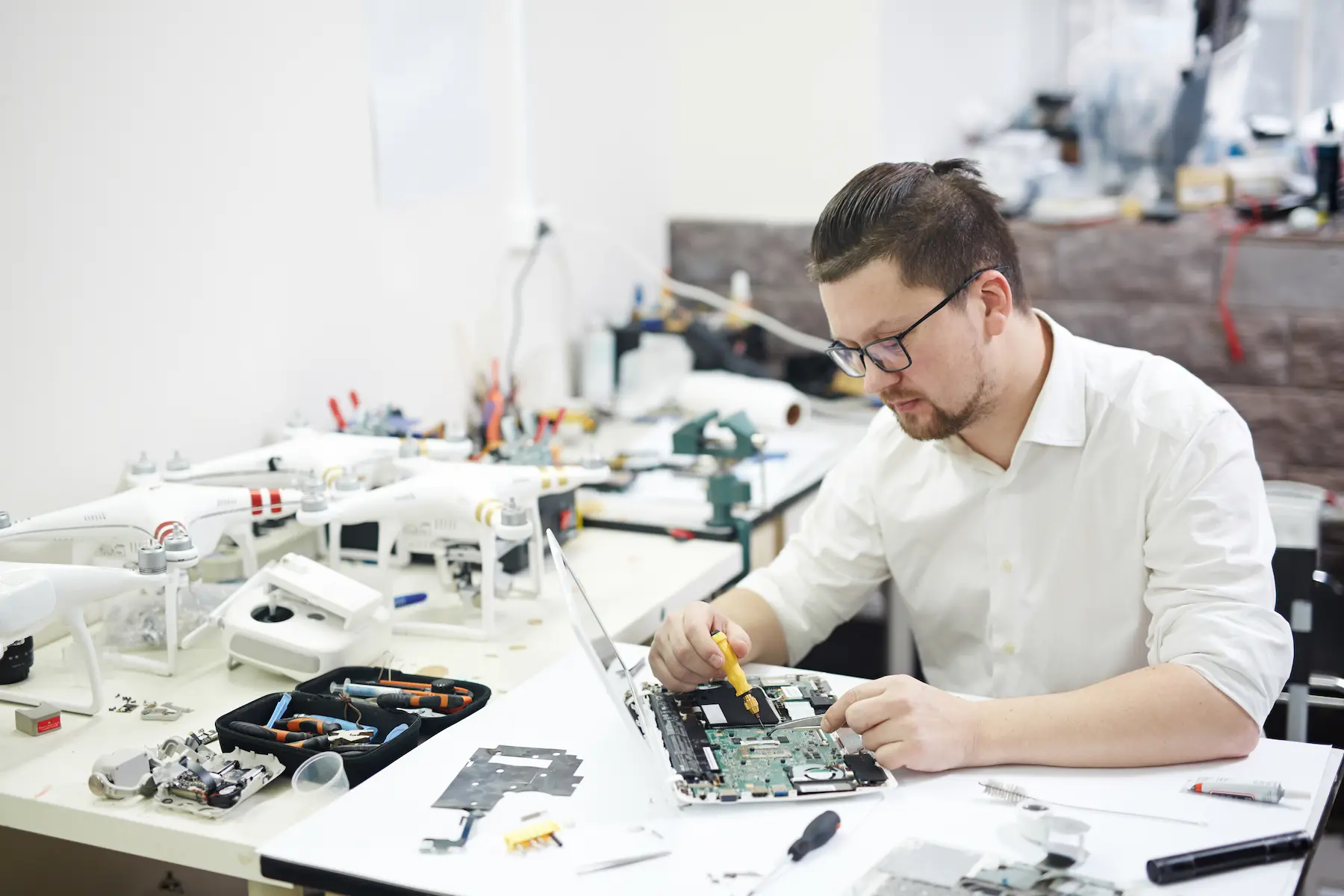 Technician repairing a circuit board at a high-volume electronics rework center.